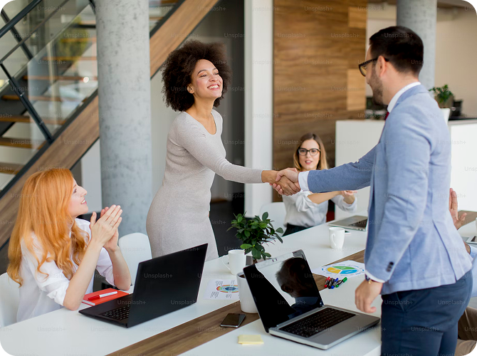 Business team celebrating successful retail media partnership deal in modern office